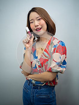 Beautiful Asian woman after makeup smile and show three in one lipstick create over lips , eyeshadow and blush onestop in cosmetic