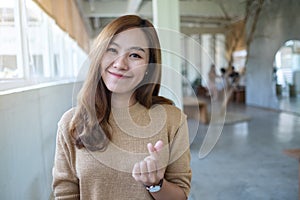 A beautiful asian woman making and showing mini heart hand sign