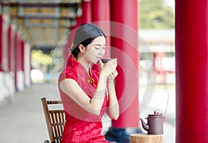 Beautiful Asian  woman in old traditional Chinese dresses drinking tea  in the Temple