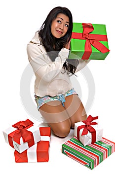 Beautiful Asian woman opening Christmas presents