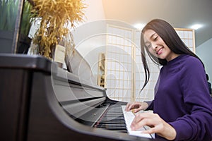 Beautiful asian woman playing piano. selective focus on face