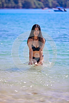 Beautiful asian woman playing with water on a tropical beach