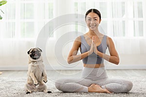 Beautiful Asian woman practice yoga lotus pose with dog pug breed enjoy and relax with yoga at home,Recreation Exercise with Dog ,
