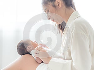 A beautiful Asian woman puts her newborn baby on her body