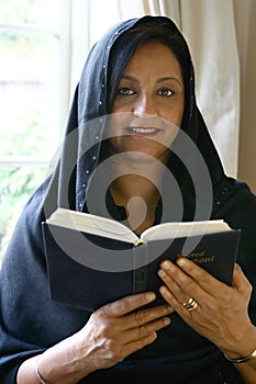 Beautiful Asian woman reading her religious book