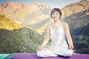 Beautiful asian woman relaxing and meditating outdoor at mountain