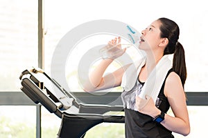 Beautiful asian woman rest drinking water bottle after treadmill