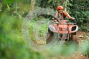 beautiful asian woman riding the atv happily through the atv arena