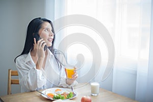 Beautiful asian woman's face lit up with a smile as she spoke on the phone showing her enjoyment of the conversation.