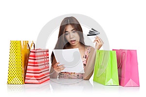 Beautiful Asian woman shock with a credit card statement and shopping bags