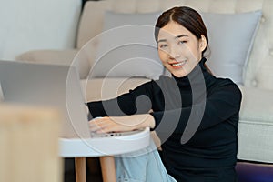 Beautiful asian woman sitting and calculating income tax in living room