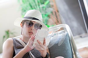 Beautiful asian woman sitting on the chair and reading a text me