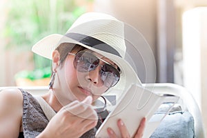 Beautiful asian woman sitting on the chair and reading a text me