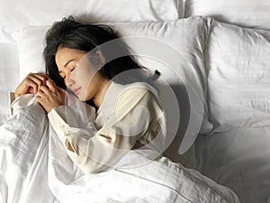 Beautiful asian woman sleeping in bed under white quilt with head on pillow comfortable and happy. girl with relax for health