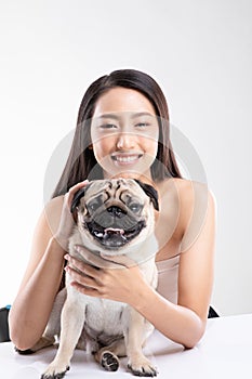 Beautiful Asian woman smile with her dog Pug breed