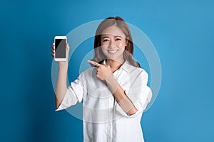 Beautiful Asian woman smiling, carrying shopping bags and showing credit cards in the studio