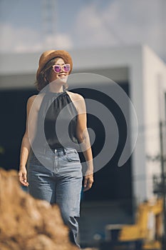 beautiful asian woman smiling with hapiness face standing outdoor against building construction site photo