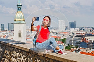 Beautiful asian woman taking selfie at the background of the city - traveler and social network concept