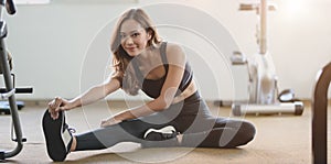 Bellissimo asiatico una donna abbronzatura un sottile corpo allungamento gambe Prima esercizio sul palestra 