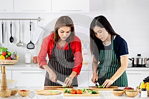 Beautiful Asian woman teaching her daughter for cooking