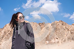 A beautiful Asian woman tourist standing in front of mountain and blue sky background