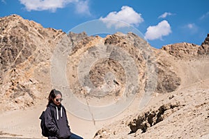 A beautiful Asian woman tourist standing in front of mountain and blue sky background