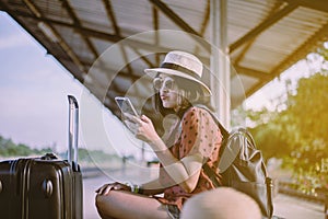 Beautiful asian woman tourist  using smart phone and waiting train at train station,Travel and vacation concept