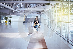 Beautiful Asian woman traveler using mobile phone in airport, Lifestyle using cell phone