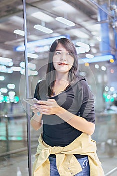 Beautiful Asian woman traveler using mobile phone in airport, Lifestyle using cell phone