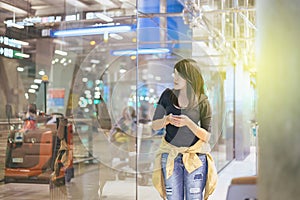 Beautiful Asian woman traveler using mobile phone in airport, Lifestyle using cell phone