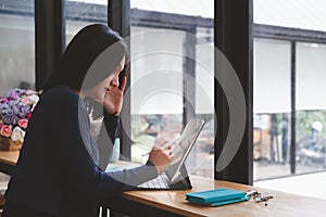 Beautiful asian woman using digital pen on tablet computer at modern office