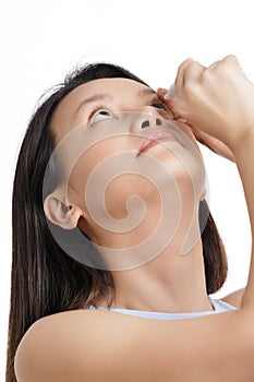 Beautiful Asian woman using eyedrops to relieve dry eyes