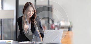 Beautiful asian woman using laptop computer, exciting and celebrating with good news of business successful. Small