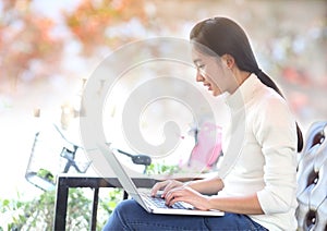 Beautiful asian woman using laptop computer in the home.