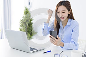 Beautiful asian woman using smartphone, exciting and celebrating with good news of business successful