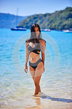 Beautiful asian woman walking on a tropical beach