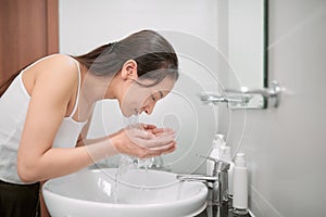 Beautiful asian woman is washing her face