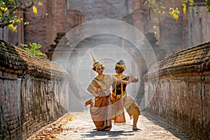 Beautiful Asian woman wear Thai traditional dress action of dancing together with Thai classic masked from the Ramakien character