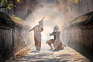 Beautiful Asian woman wear Thai traditional dress action of dancing together with Thai classic masked from the Ramakien character