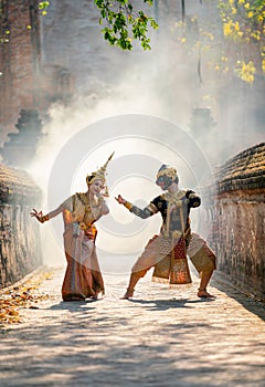 Beautiful Asian woman wear Thai traditional dress action of dancing together with Thai classic masked from the Ramakien character