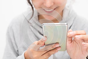 Beautiful Asian woman wearing grey casual shirt holding smartphone on white background and copy space.  Cute Asian woman is