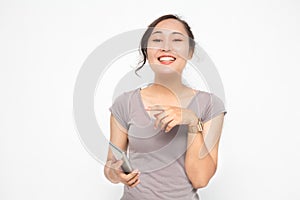 Beautiful Asian woman wearing grey casual shirt holding smartphone on white background and copy space.  Cute Asian woman is