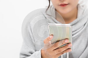 Beautiful Asian woman wearing grey casual shirt holding smartphone on white background and copy space.  Cute Asian woman is