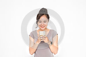 Beautiful Asian woman wearing grey casual shirt holding smartphone on white background and copy space.  Cute Asian woman is