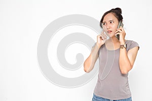 Beautiful Asian woman wearing grey casual shirt holding smartphone on white background and copy space.  Cute Asian woman stressed