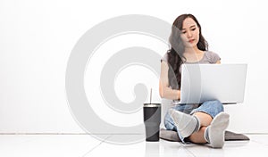 Beautiful Asian woman wearing grey casual shirt using laptop on white background and copy space. Cute Asian woman sitting on the
