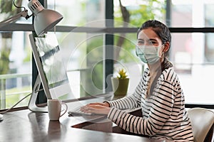 Beautiful asian woman wearing protection mask work from home in the morning. Young asian female working with computer stay at home