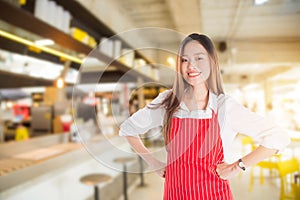 Beautiful asian woman wearing red apron smiling