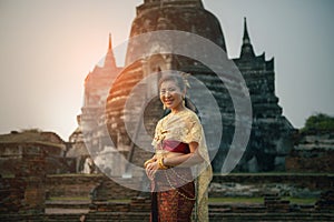 beautiful asian woman wearing thai tradition dress smiling with happiness standing against old stupa in ayutthaya world heritage