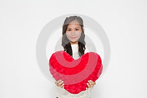 Beautiful Asian woman wearing white sweater holding red heart shape pillow on white background and copy space for Valentine Day